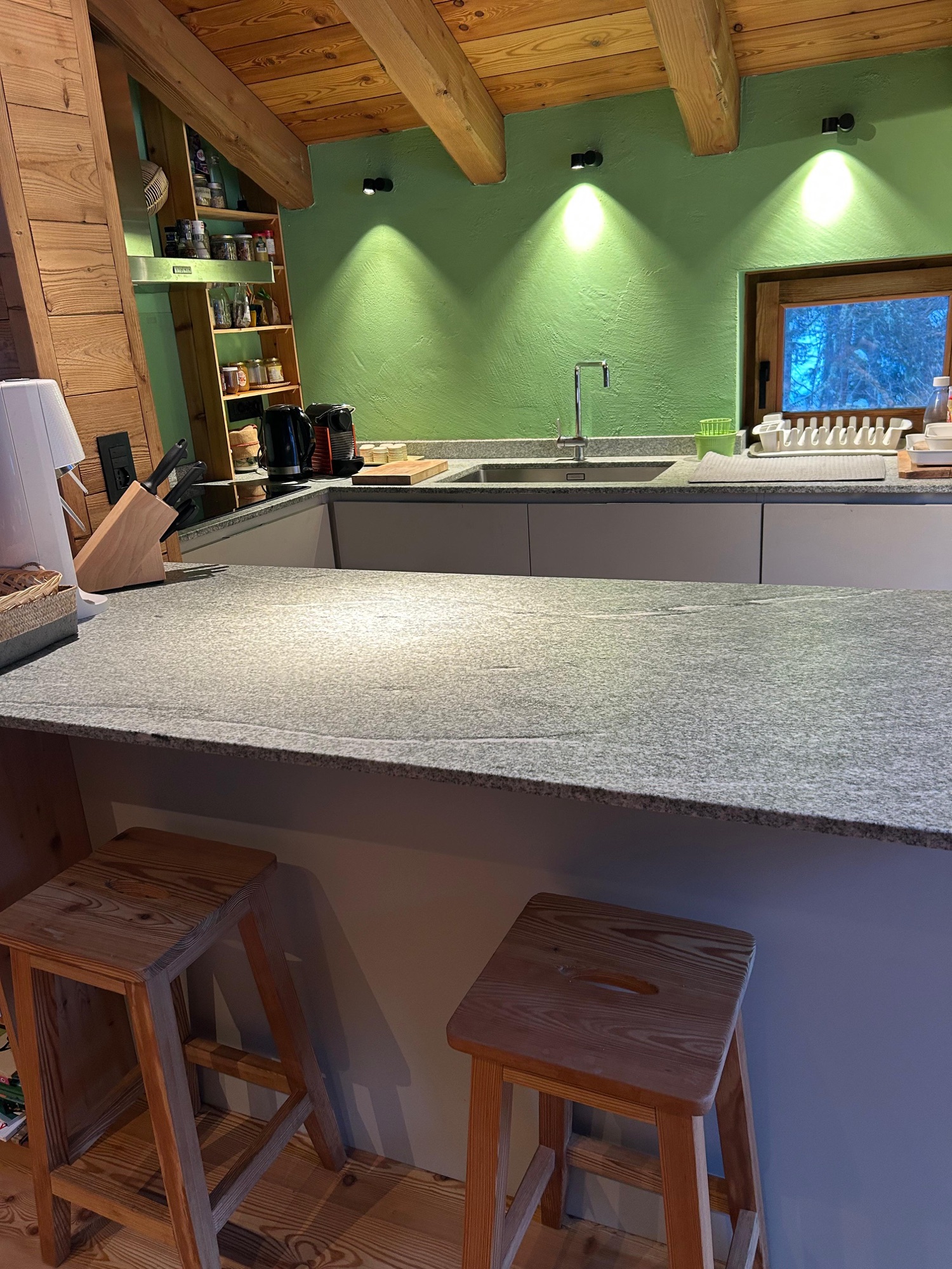 Kitchen with stone island and wooden stools
